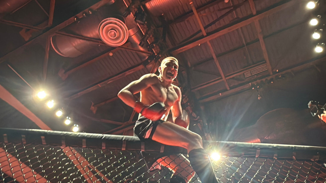 Connor Brennan sitting on top of the cage after his win. 